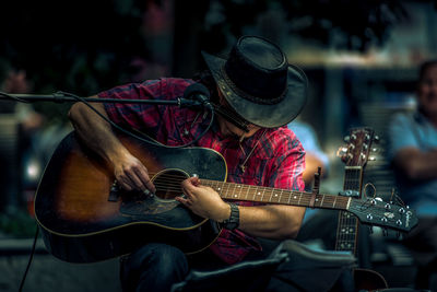 Midsection of man playing guitar