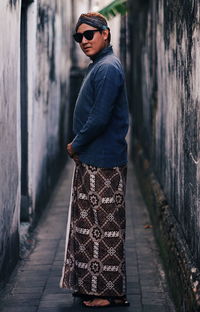 Man wearing sunglasses standing amidst wall