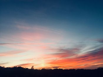 Low angle view of silhouette trees against romantic sky