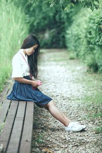 Full length of teenage girl sitting on grass