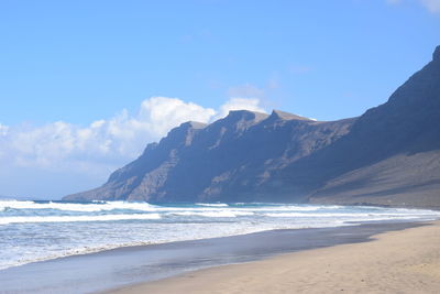 Scenic view of sea and mountains against sky