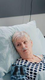 Portrait of young woman lying on bed at home