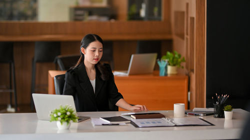 Portrait of young businesswoman working at table