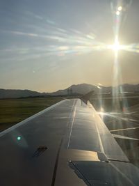 Airplane flying in sky at sunset