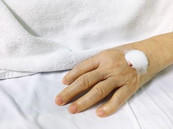 Close-up of woman hand on bed
