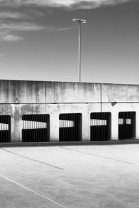 Empty road by building against sky