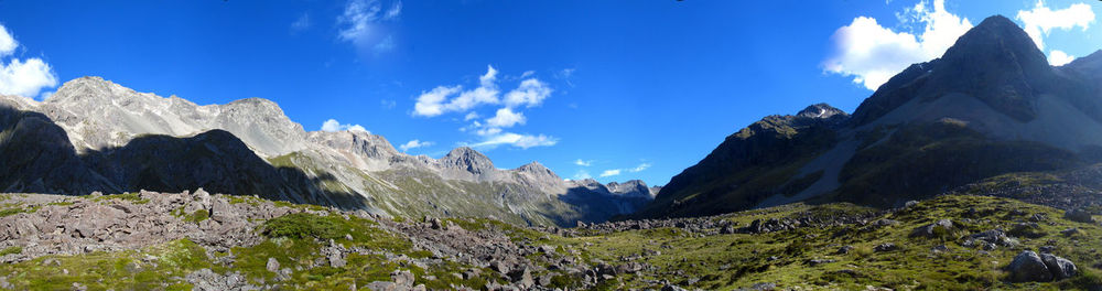 Low angle view of snowcapped mountains against blue sky