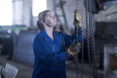 Woman pulling a chain in workshop