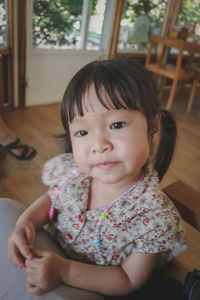 Portrait of cute girl sitting at home