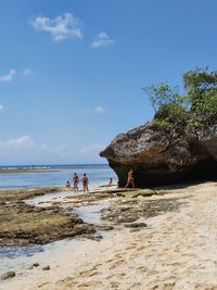 People on beach against sky