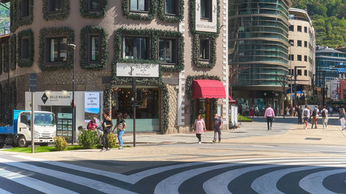 People walking on street against buildings in city