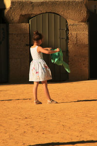 Woman holding umbrella while standing outdoors