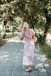 Rear view of woman walking on footpath