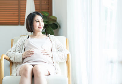 Beautiful young woman sitting on chair