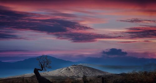 Scenic view of snowcapped mountains against cloudy sky