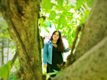 Portrait of young woman seen from tree