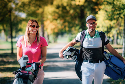 Couple on the golf course, walking to the next hole, enjoying a beautiful sunny autumn day