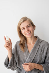 Portrait of a smiling young woman against white background