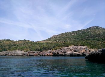 Scenic view of sea and mountains against sky