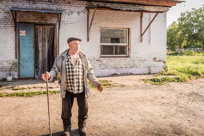 Full length of man standing outside house