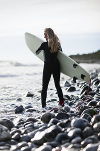 Woman with surfboard on beach