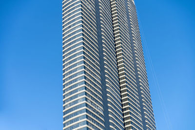 Low angle view of modern building against blue sky