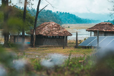 Built structure on field by buildings against sky