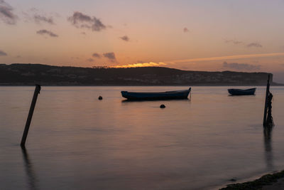 Fishing boats on a river sea at sunset in foz do arelho, portugal