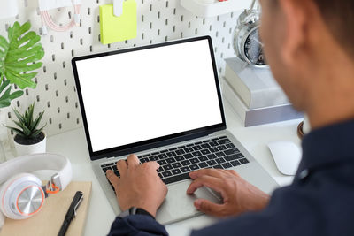 Midsection of man using laptop on table