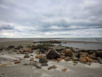 Rocks on beach against sky