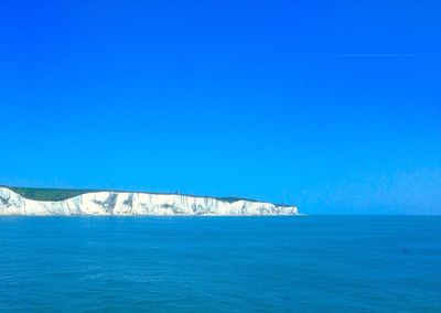 Scenic view of sea against clear blue sky