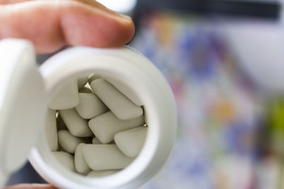 Cropped hand holding bottle with pills