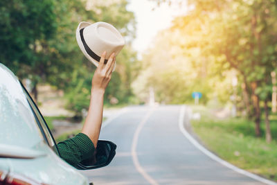 Man holding umbrella by road