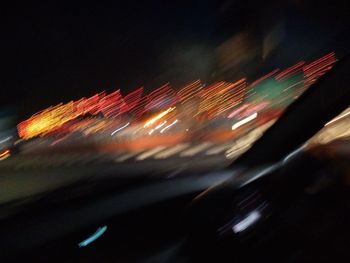 Close-up of illuminated light trails against sky at night