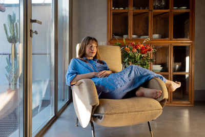 Portrait of woman sitting on sofa at home