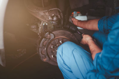 Midsection of man repairing car