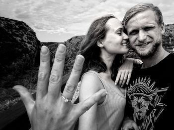 Woman standing with husband showing ring