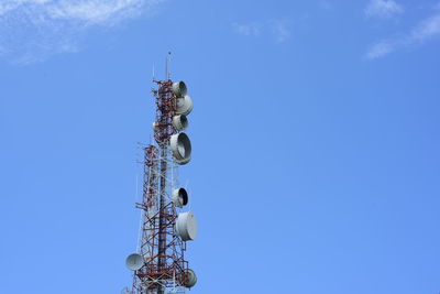 Low angle view of communications tower against blue sky