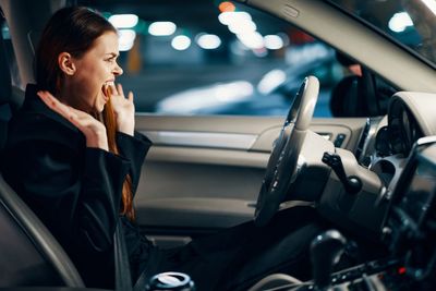 Angry young woman sitting in car