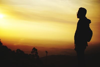 Silhouette man standing against sky during sunset