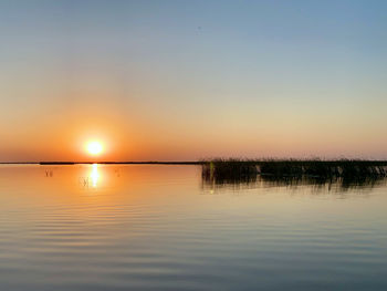 Scenic view of lake against romantic sky at sunset