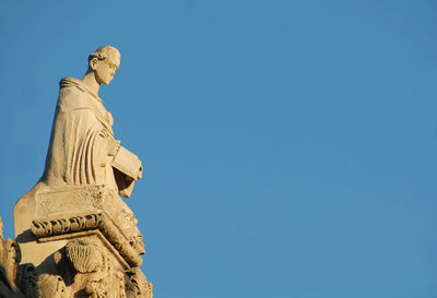 Low angle view of statue against blue sky