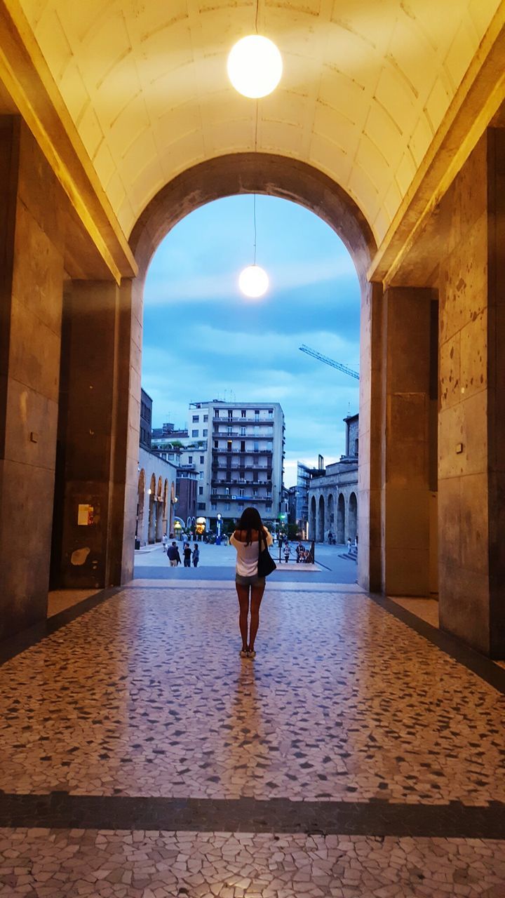 architecture, built structure, lifestyles, building exterior, men, walking, indoors, full length, sky, leisure activity, rear view, person, city, arch, city life, the way forward, building, standing