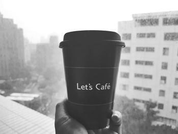 Close-up of hand holding coffee cup