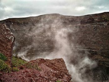 Smoke emitting from volcanic mountain against sky