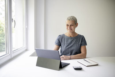 Portrait of young man using laptop at home