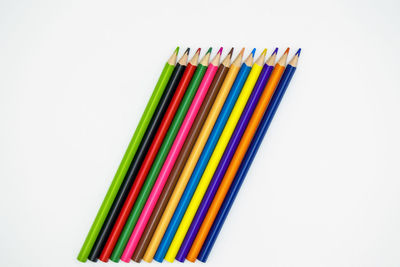 Close-up of colored pencils over white background