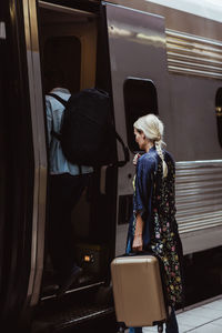 Couple with luggage boarding train at station