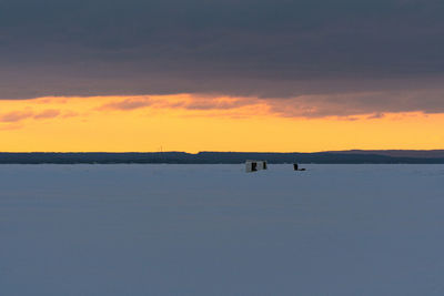 Scenic view of lake against orange sky