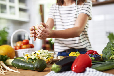 Midsection of teenage girl preparing food in kitchen at home